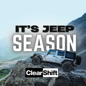 Jeep Wrangler Rubicon parked on rocky mountain terrain, overlooking a scenic valley below.