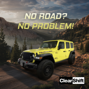 Yellow Jeep Wrangler Rubicon driving on a rugged mountain road with no visible pavement.