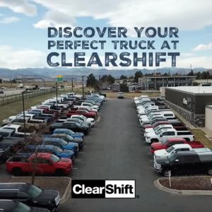 Aerial view of ClearShift dealership lot with trucks in the foreground and Colorado mountains in the background.